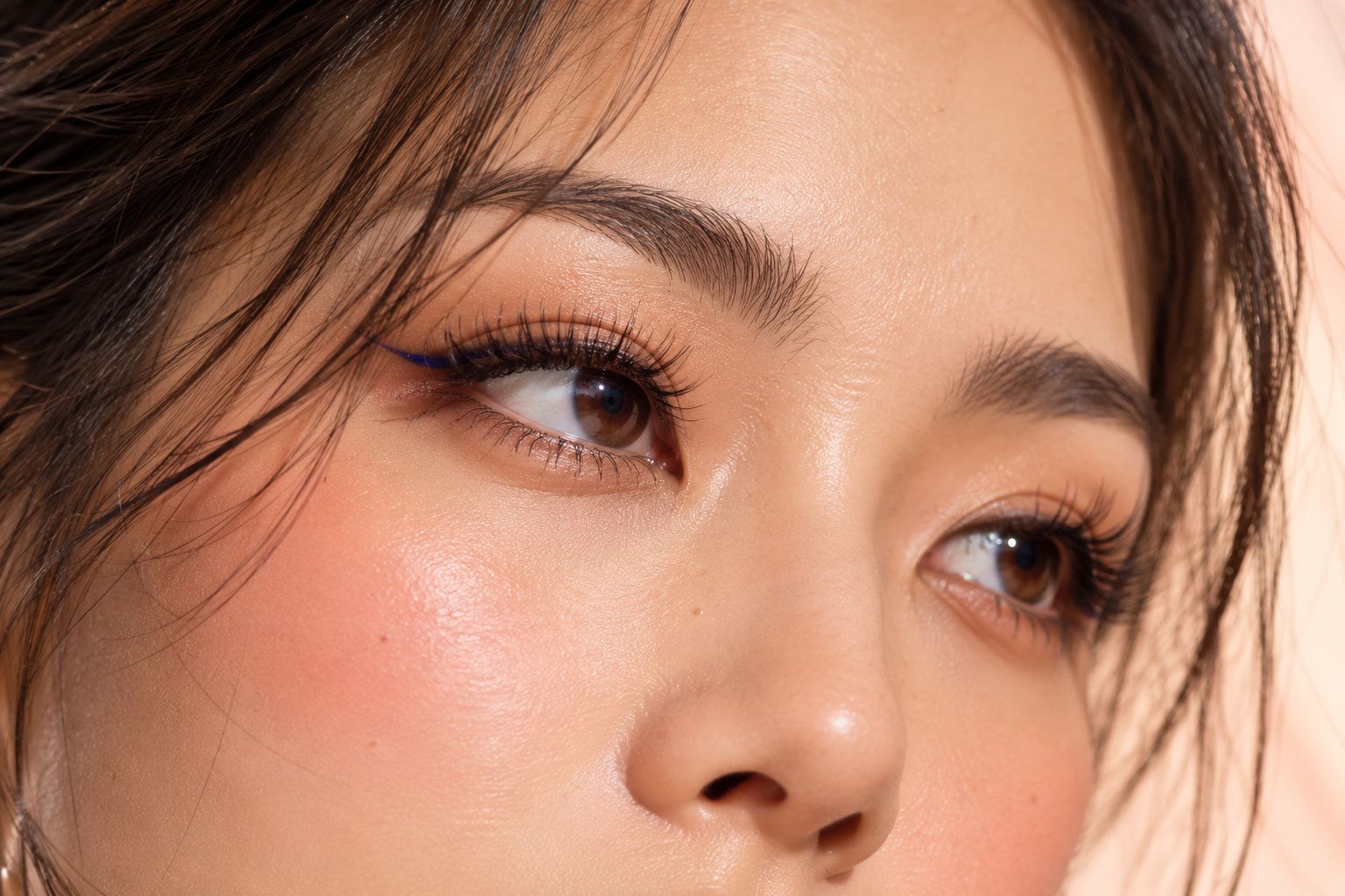 Close-up of an eye with full, curled lashes and a fine winged liner.