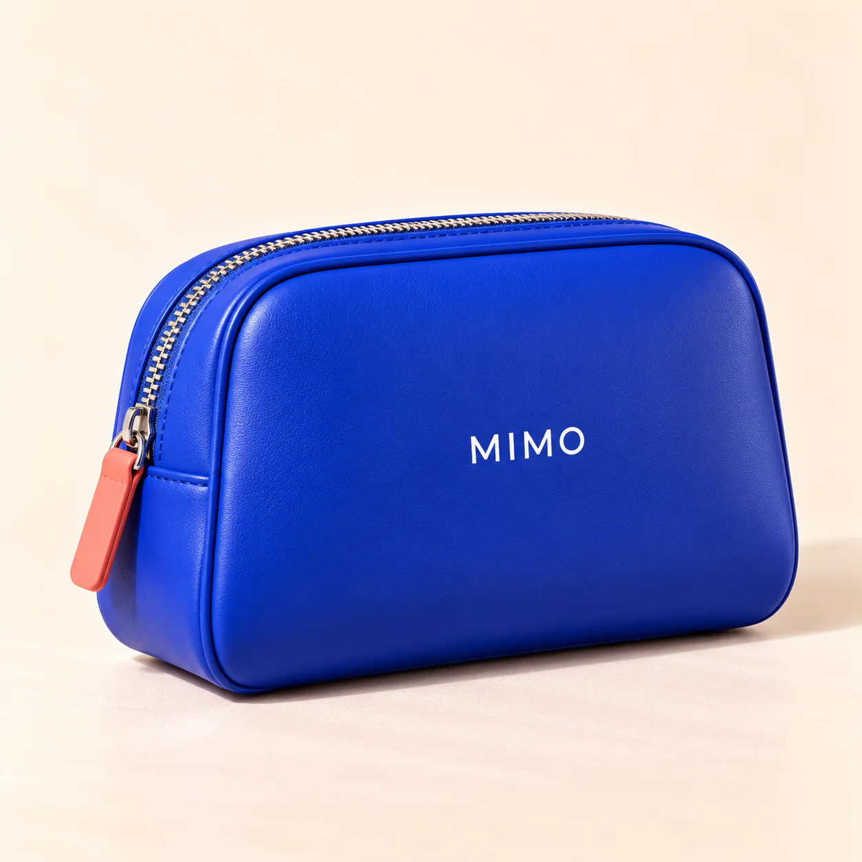 MIMO Beauty Bag: a cobalt zip pouch with a coral zip pull and the MIMO logo.