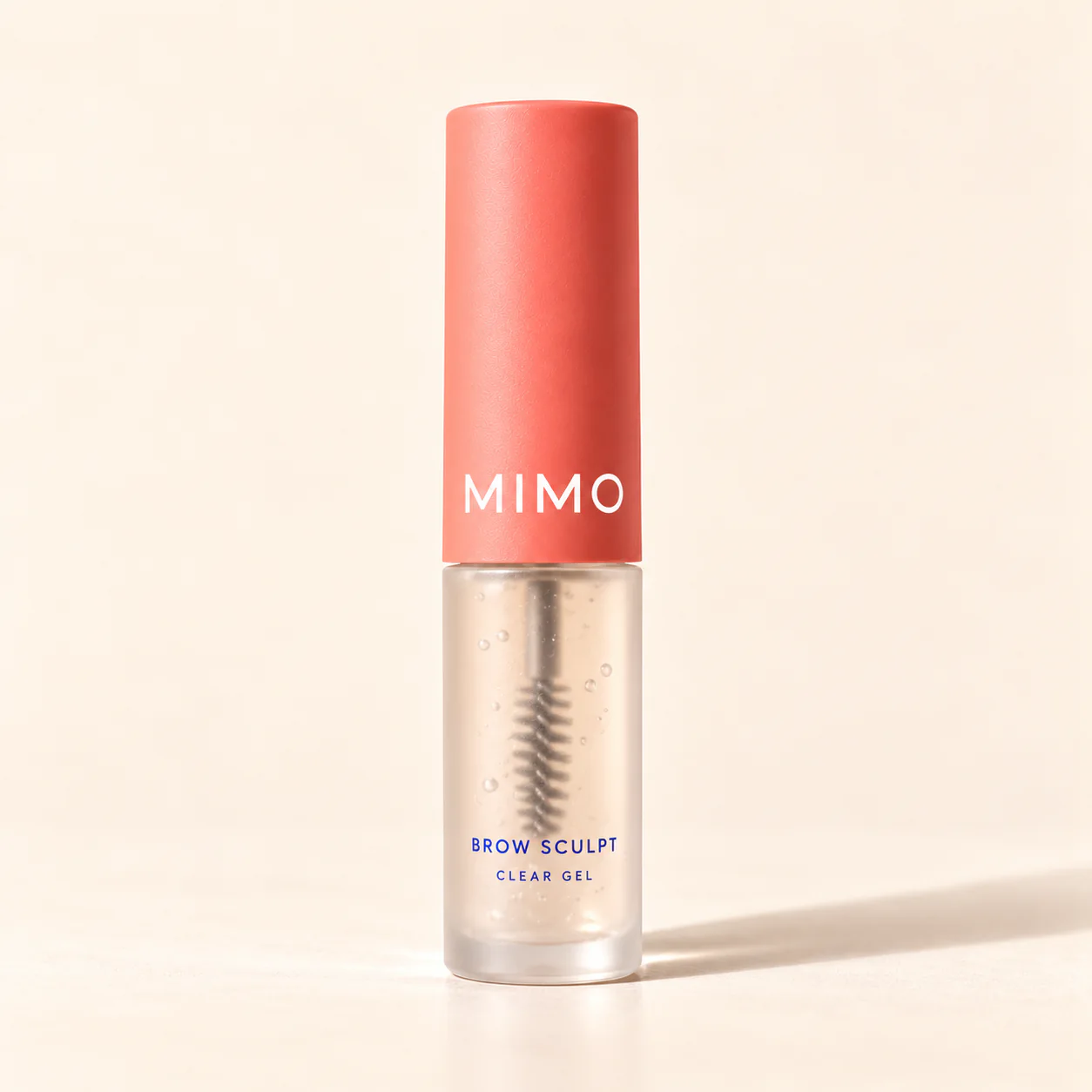 MIMO Brow Sculpt Clear Gel: a clear tube with a visible spoolie and a coral cap.