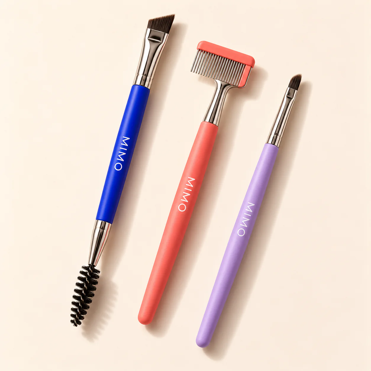 MIMO Brow Tools Set: an angled brush with spoolie, a brow comb and a fine brush with cobalt, coral and lavender handles.