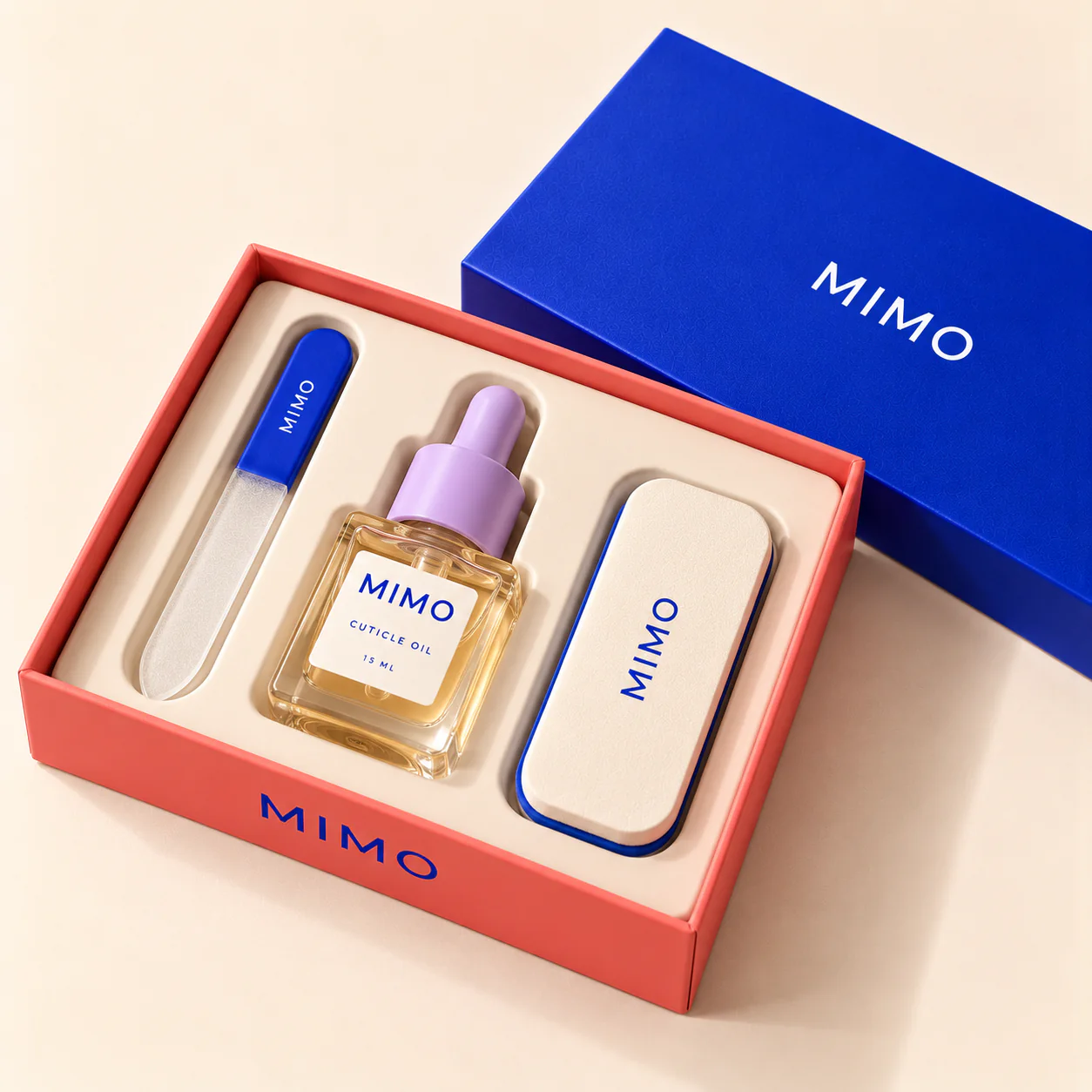 MIMO Essential Nail Care Kit: an open coral box with a glass nail file, cuticle oil and a MIMO tin, its cobalt lid beside it.