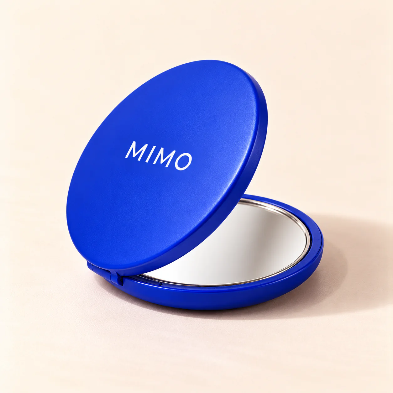MIMO Pocket Beauty Mirror: a round cobalt compact, half open.